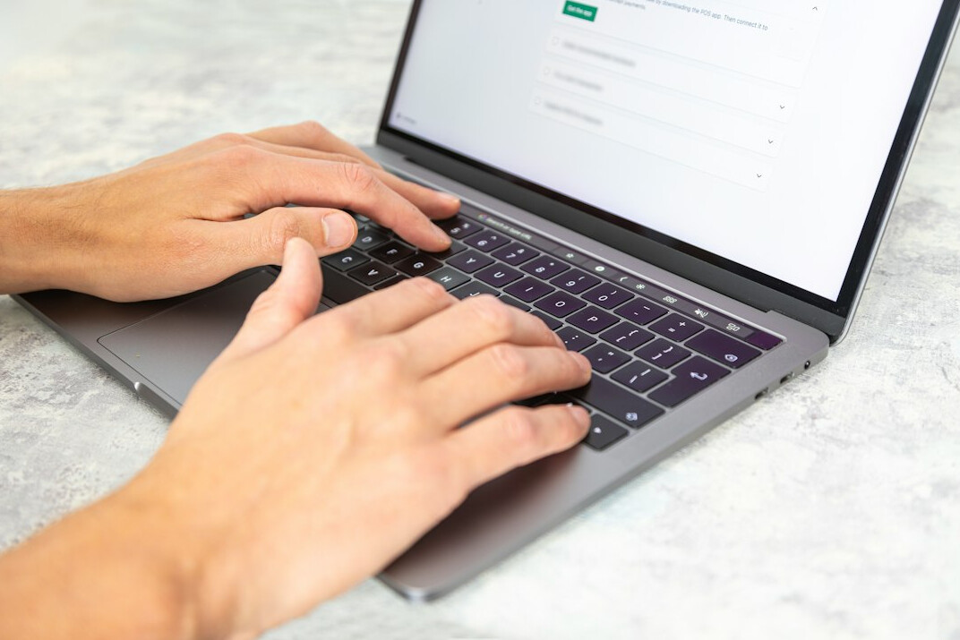 person typing code on laptop