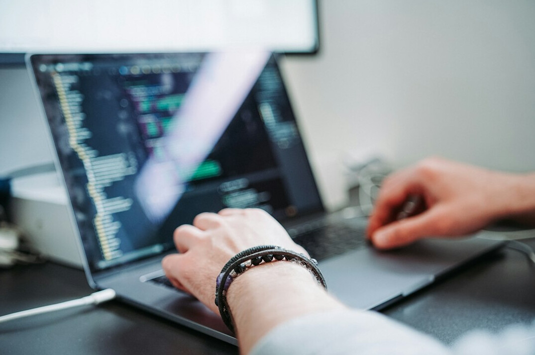 young developer coding on laptop