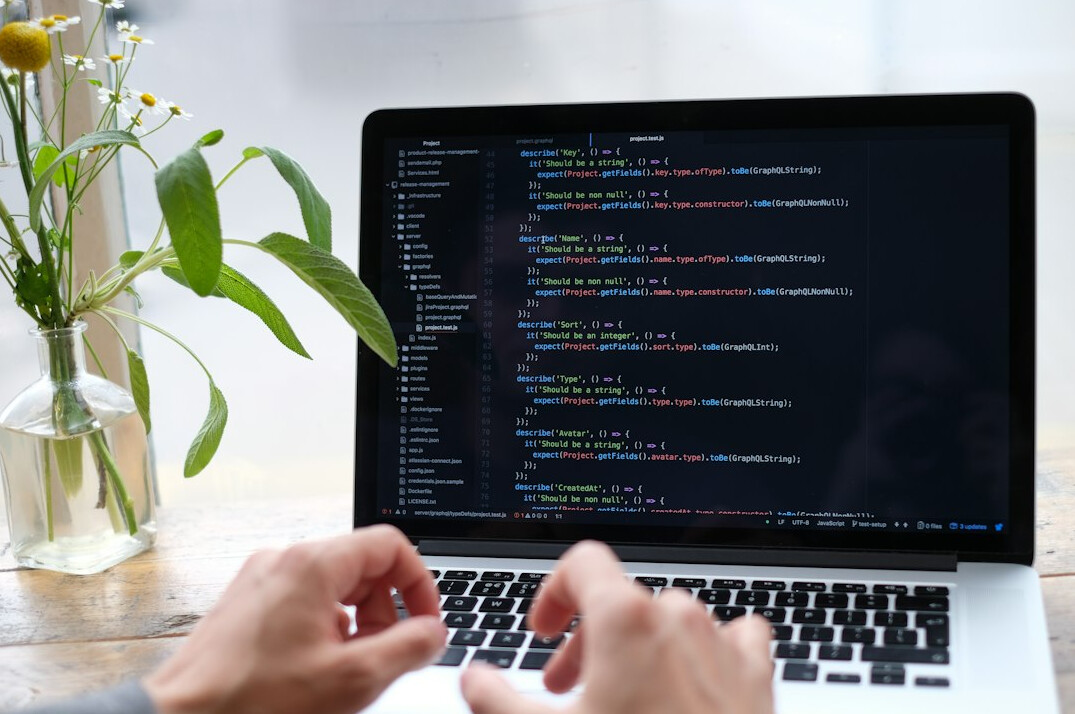 young developer coding on laptop