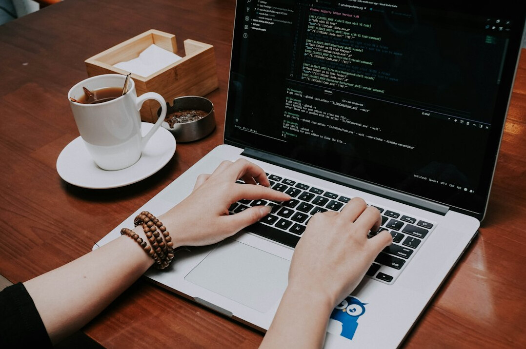 person coding on laptop